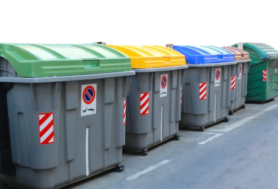 A row of garbage cans sitting on the side of a road.